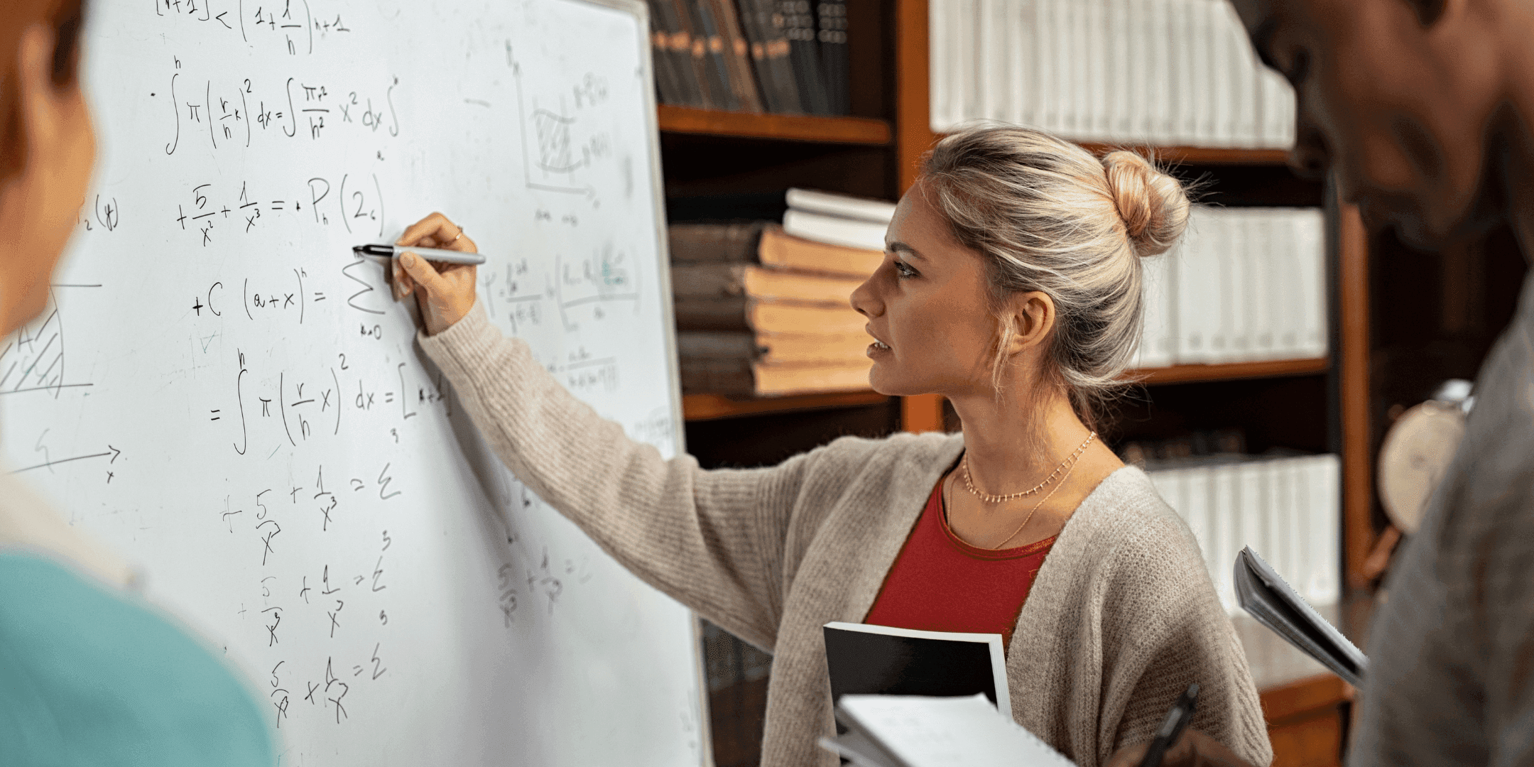 A student solving maths problem on whiteboard